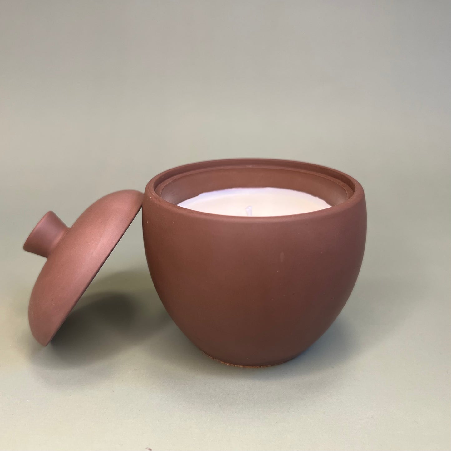 Vela em recipiente artesanal de cor cacau escuro