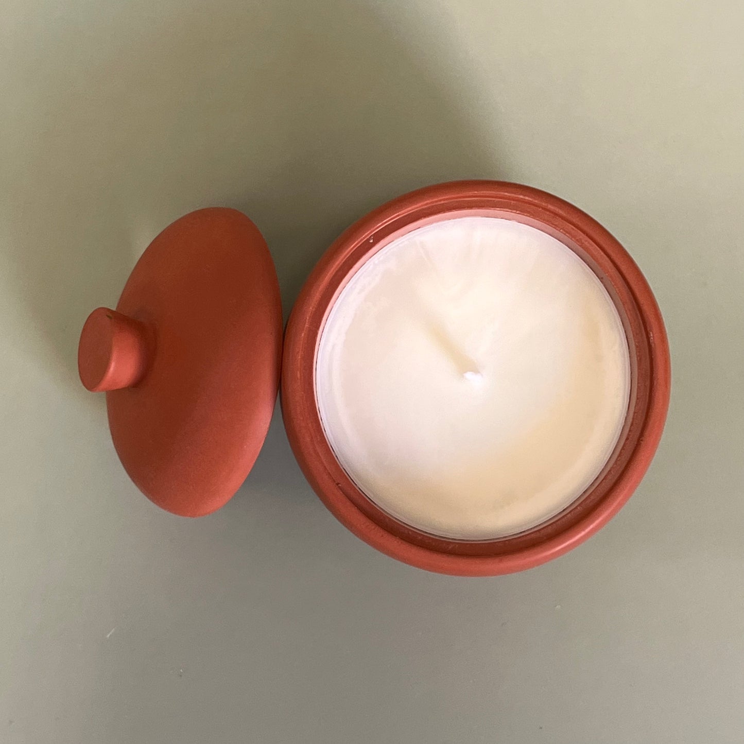 Vela num recipiente feito à mão na cor enferrujada do outono