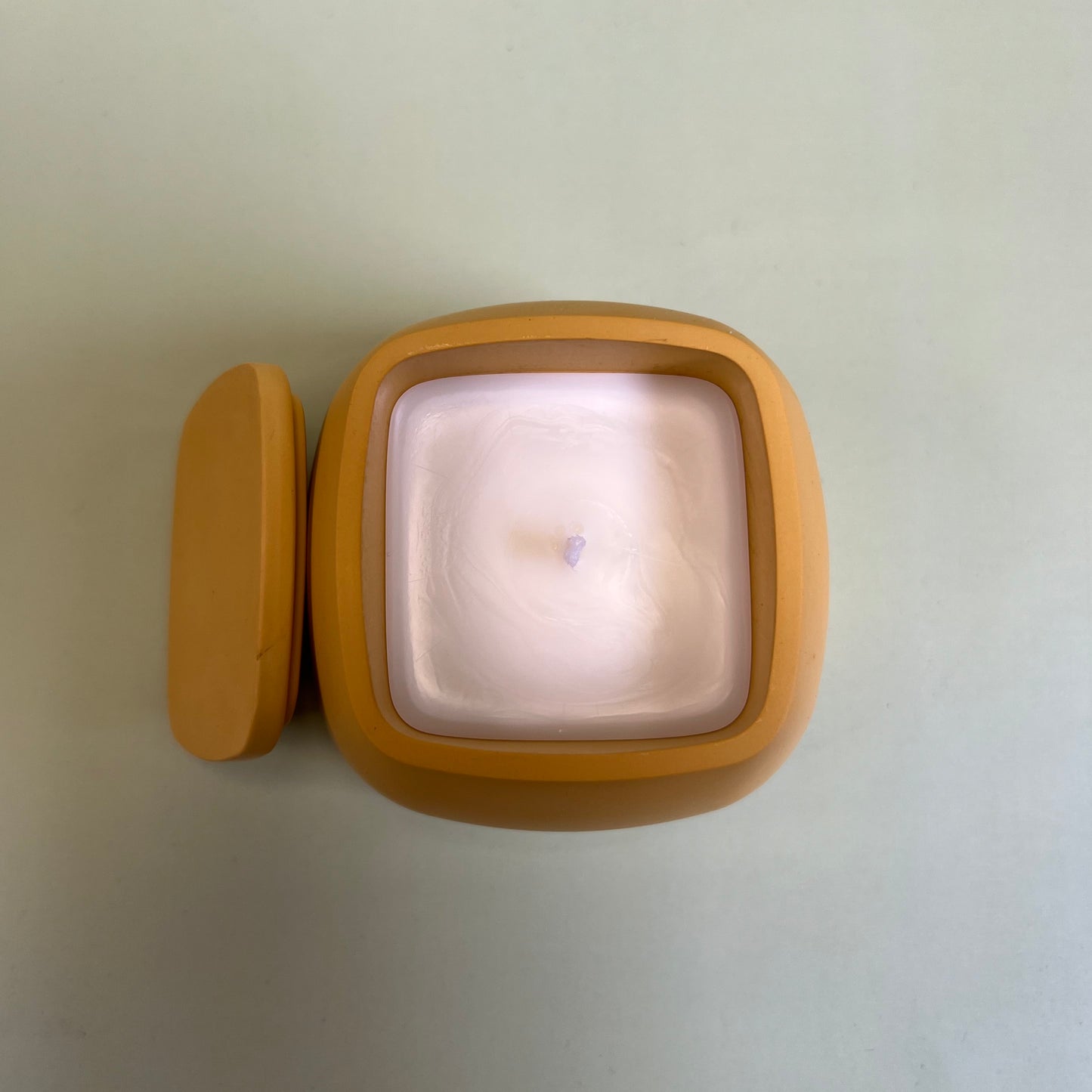 Vela num recipiente amarelo feito à mão