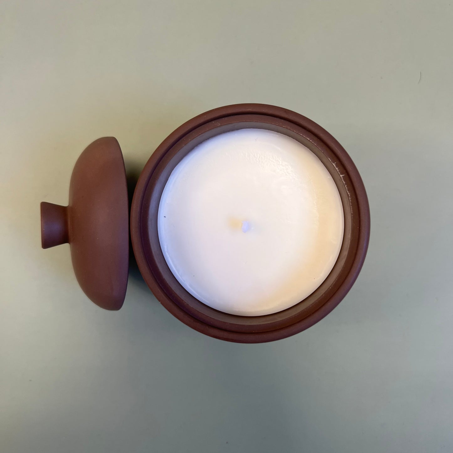 Vela em recipiente artesanal de cor cacau escuro