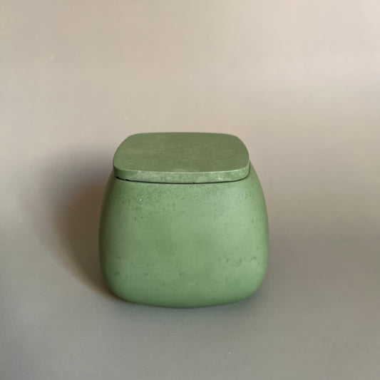 Vela em recipiente feito à mão com folha verde